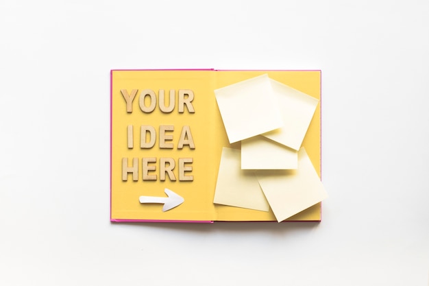 Free photo your idea here text with arrow symbol directing towards sticky notes on book