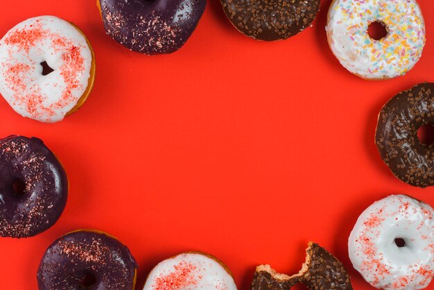 Yummy different chocolate bitten doughnuts with colorful sprinkles