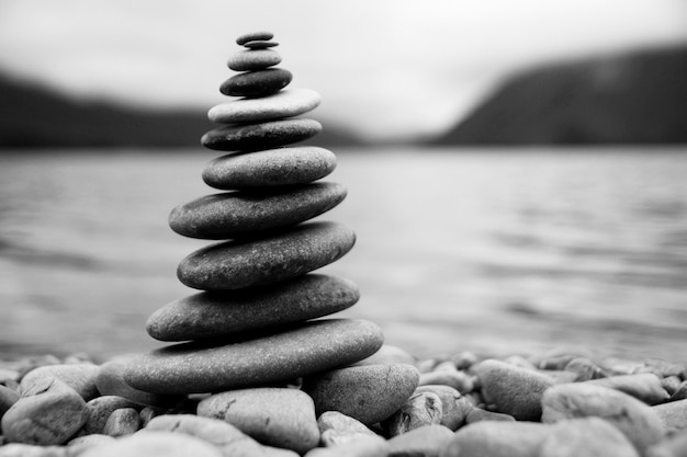 Free photo zen balancing pebbles next to a misty lake