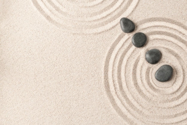 Free photo zen stones sand background health and wellness concept