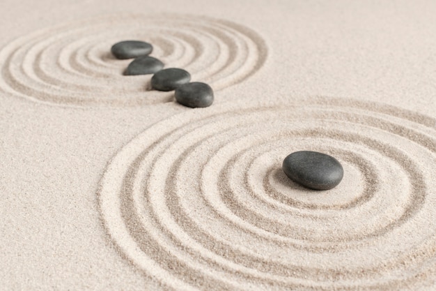 Free photo zen stones sand background health and wellness concept