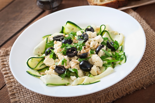 Zucchini salad with feta, olives and pine nuts