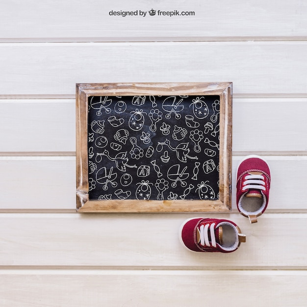 Free PSD baby mockup with slate and little shoes