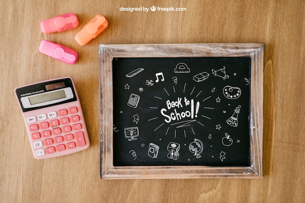 Free PSD back to school composition with slate and calculator on wooden surface