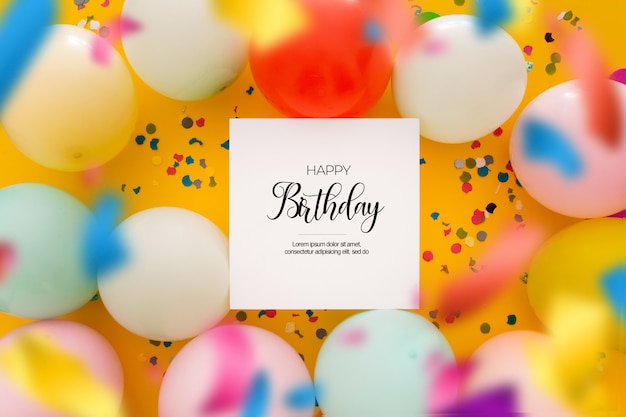 Birthday background with a unfocused confetti and balloons on yellow