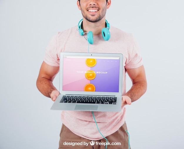 Free PSD happy guy holding laptop's mock up