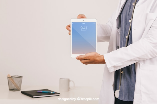 Free PSD mock up design with doctor's hands holding tablet