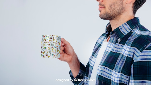 Free PSD mock up design with young guy holding coffee mug