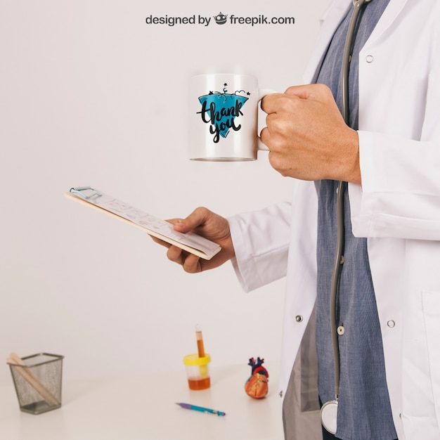 Free PSD mock up with doctor holding coffee mug and clipboard