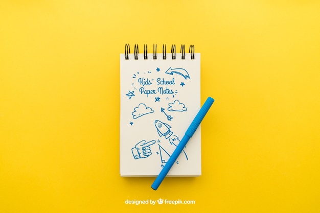 Notepad with pencil on yellow background