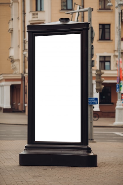 Free PSD photo of a large billboard that stands on the street, where many people walk