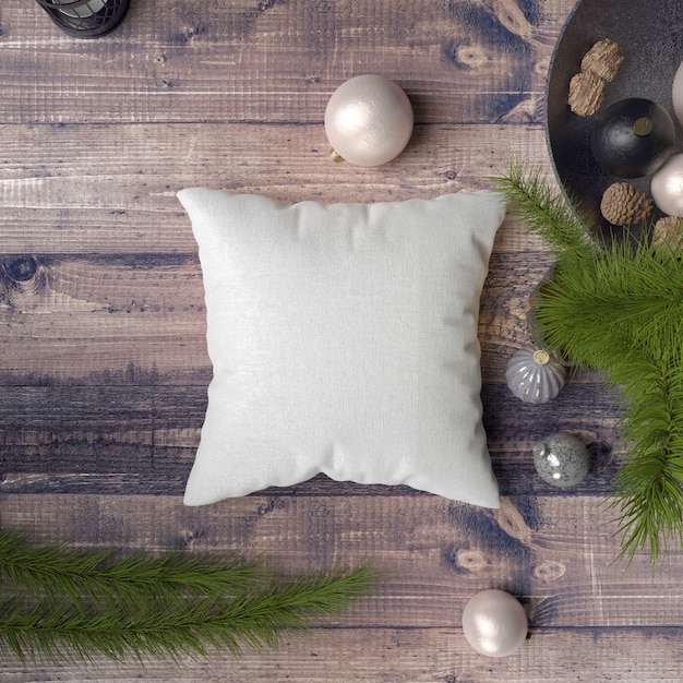 Free PSD pillow on a wooden table surrounded by baubles, pines and fir