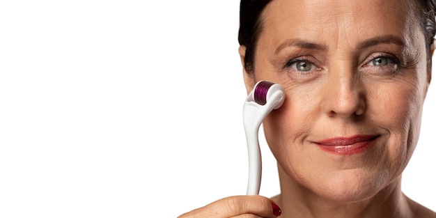 Free PSD portrait of senior woman with derma roller for skincare