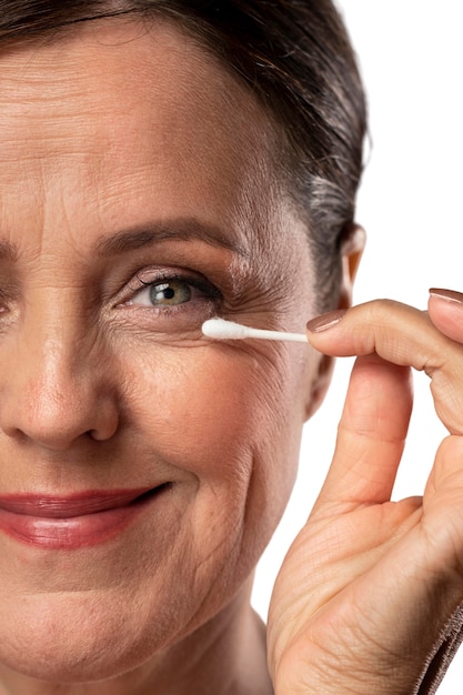 Free PSD portrait of senior woman with q-tip for cleaning skin