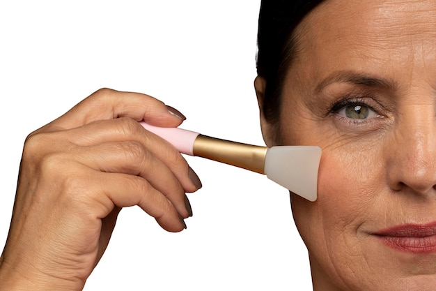 Free PSD portrait of senior woman with silicon brush for skincare