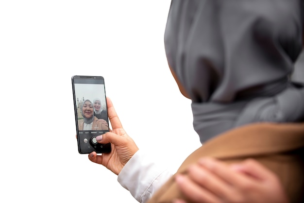 Portrait of woman wearing islamic hijab and taking selfie