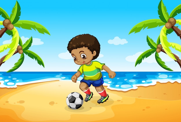 A boy playing football at the beach