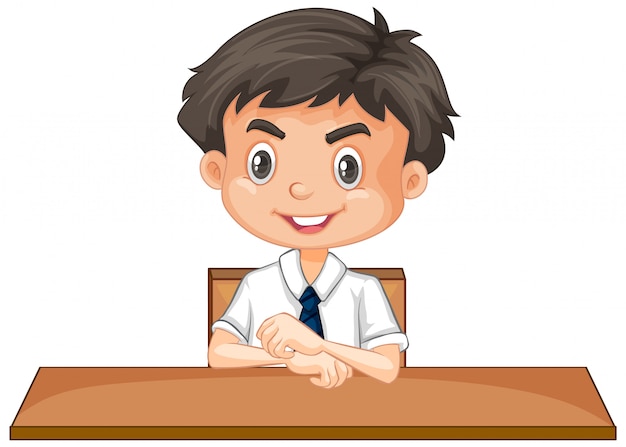 Boy in school uniform sitting at desk on white