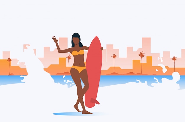 Dark skinned girl holding surfboard