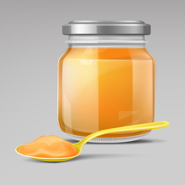 Glass baby food jar and plastic spoon with puree