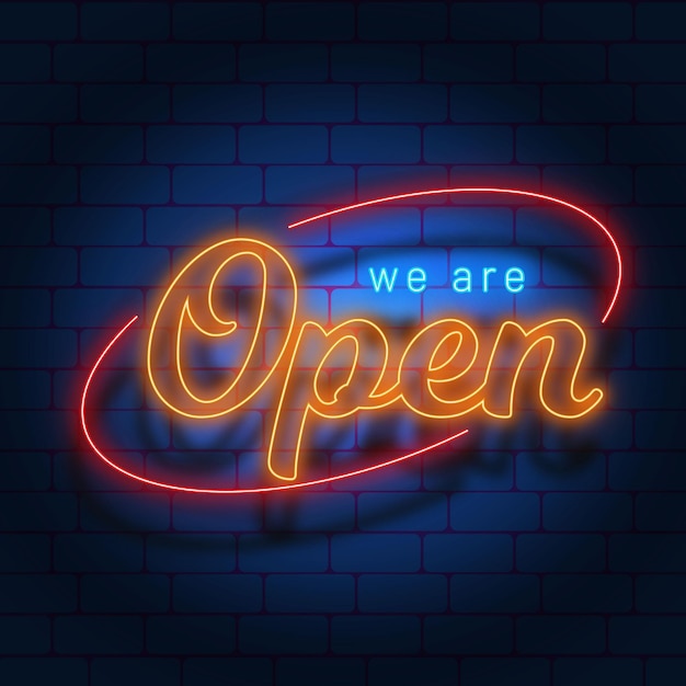 'we are open' sign on brick wall