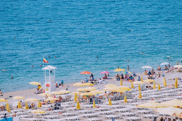 04 June 2022 Antalya Turkey Crowded city beach with hundreds of vacationers and tourists resting sunbathing and swimming at extremely hot summer day in resort town