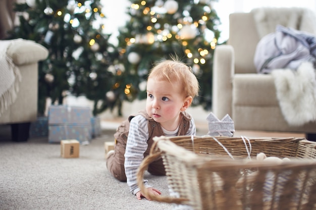 1 year old baby boy crawling on floor at home.