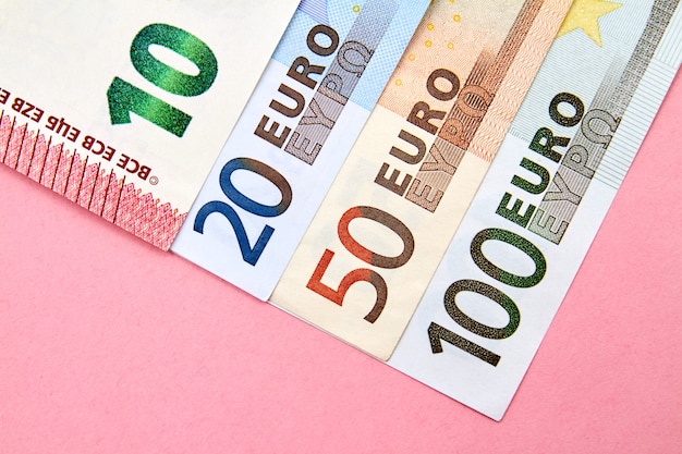 10, 20, 50, 100 Euro banknotes on pink background