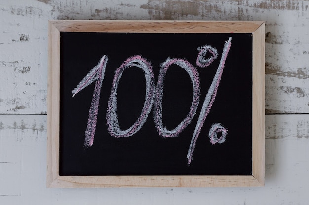 100 percent 100 written on blackboard top view One hundred Sales and discount concept Goals an