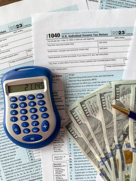 1040 tax form with pen calculator and dollar money