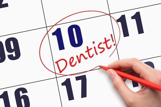 10th day of the month Hand writing text DENTIST and circling the calendar date