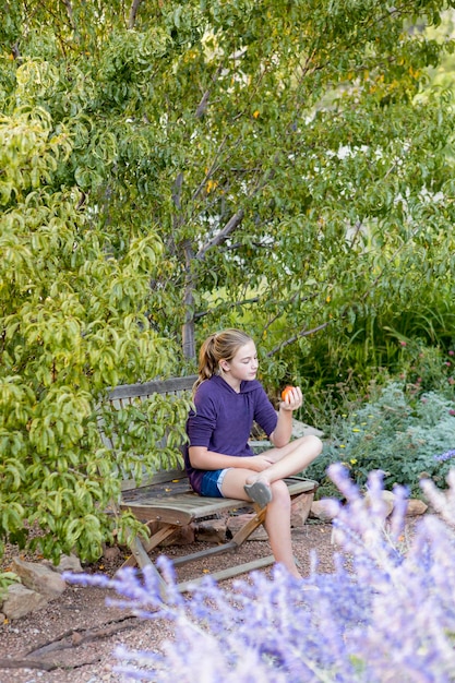 11 year old girl sitting on bench reading a book