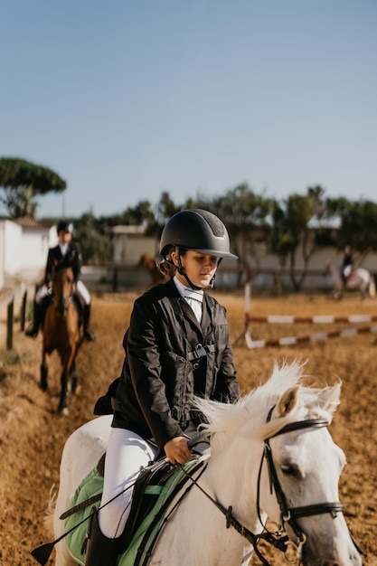 12yearold girl jogging white pony at riding school