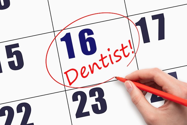 16th day of the month Hand writing text DENTIST and circling the calendar date