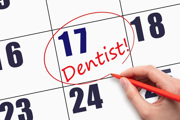 17th day of the month Hand writing text DENTIST and circling the calendar date