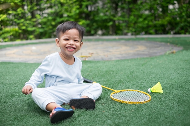 1yearold Asian boy wearing blue sitting with badminton at home