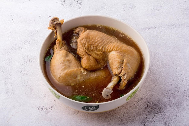 2 big Chicken leg quarters chicken spicy soup in bowl on table, Top view.