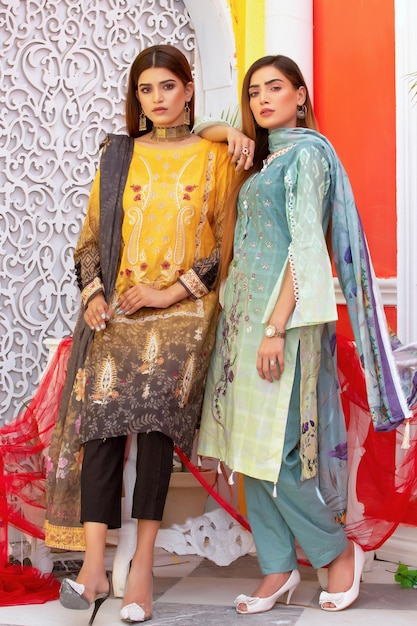 2 Gorgeous Young Girls Standing for Fashion Photoshoot Wearing Traditional Dresses