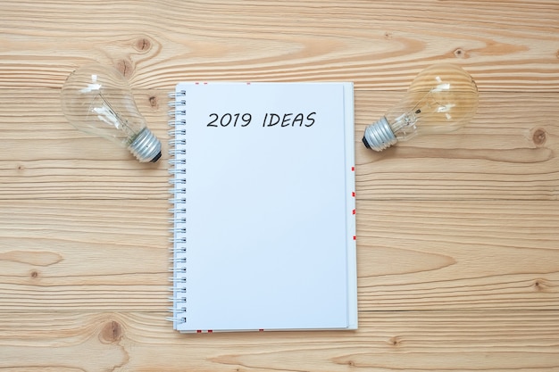 2019 Idea with lightbulb  and crumbled paper  on table. New Year Start