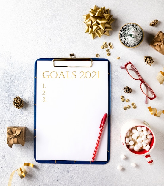 2021 New Year Goals. Christmas decorations  with wish list text on notepad. Flat lay