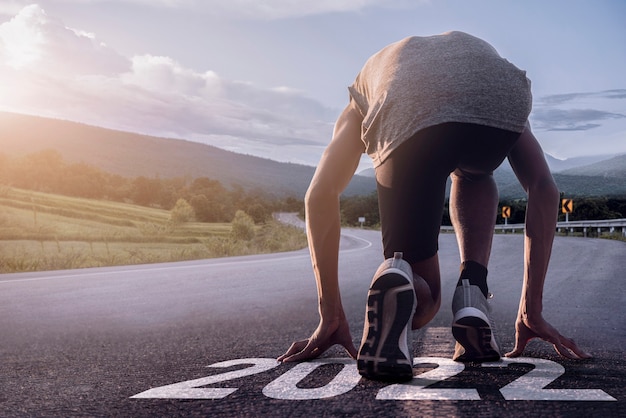 2022 background. Runner feet running on road closeup on shoe. Concept starting 2022.