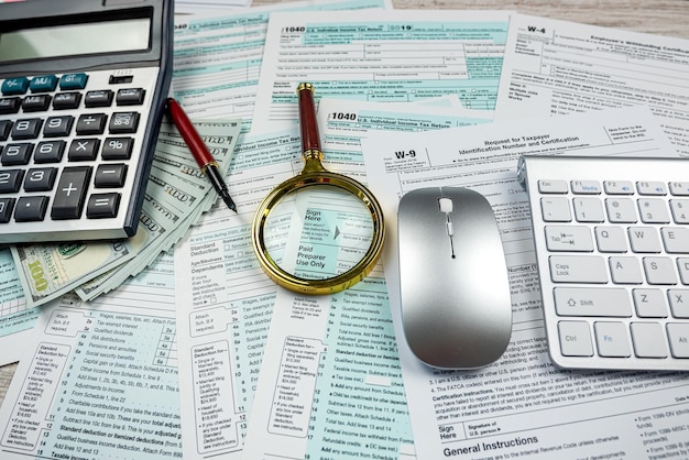 2022 blank tax form with us dollar bills claculator pen on desk