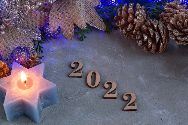 2022 christmas composition in silver blue color blue garland candle and spruce branches