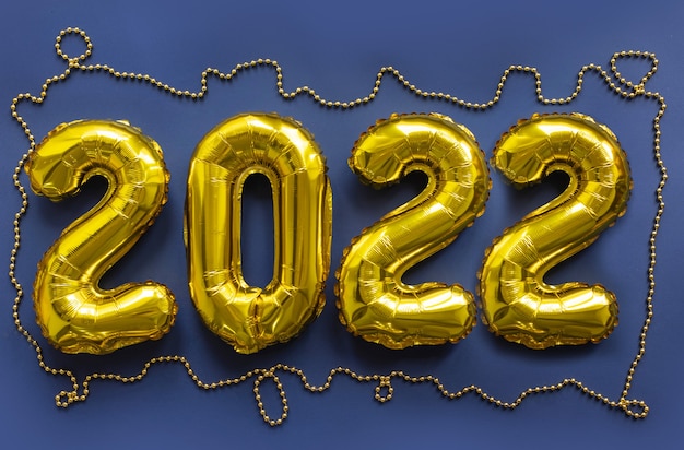 2022 gold inflatable figures numbers on a blue background. New Year concept