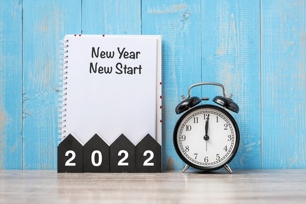 2022 Happy New Year with New Year New start, black retro alarm clock and wooden number.Resolution, Goals, Plan, Action and Mission Concept