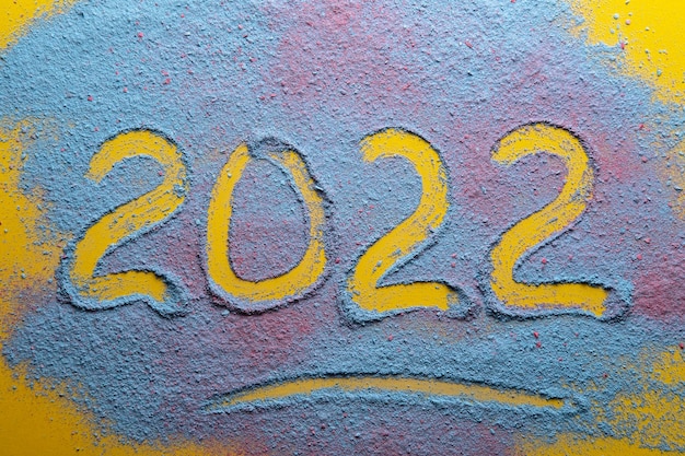 2022 is written on a multicolored bright powder