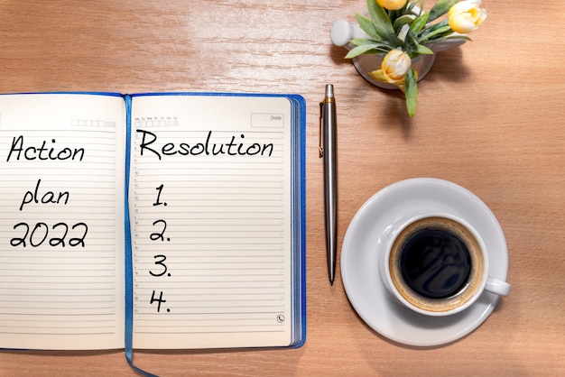 2022 New Year Resolution Goal List desk with notebook written in handwriting about plan listing of new year goals and resolutions setting Change and determination concept