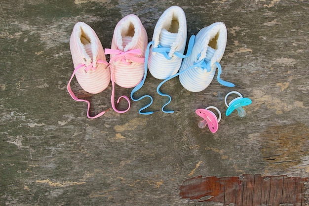 Photo 2022 new year written laces of children's shoes and pacifier on old wooden background. top view. flat lay. space for text.