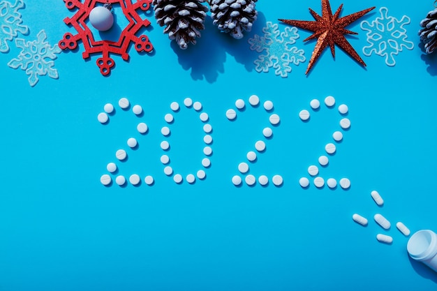 2022 new year written with white pills and new year decorations the concept of medical treatment