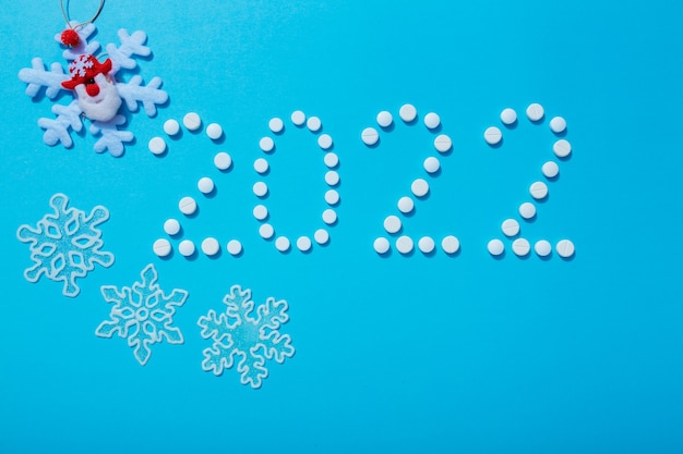 2022 new year written with white pills and new year decorations the concept of medical treatment